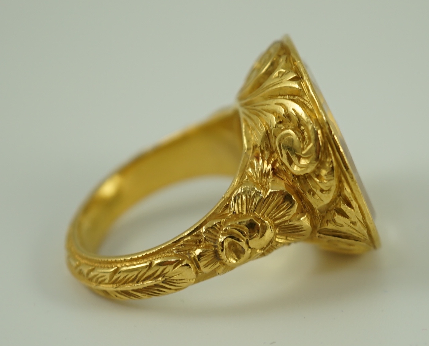 A large antique style gold and intaglio white stone set ring